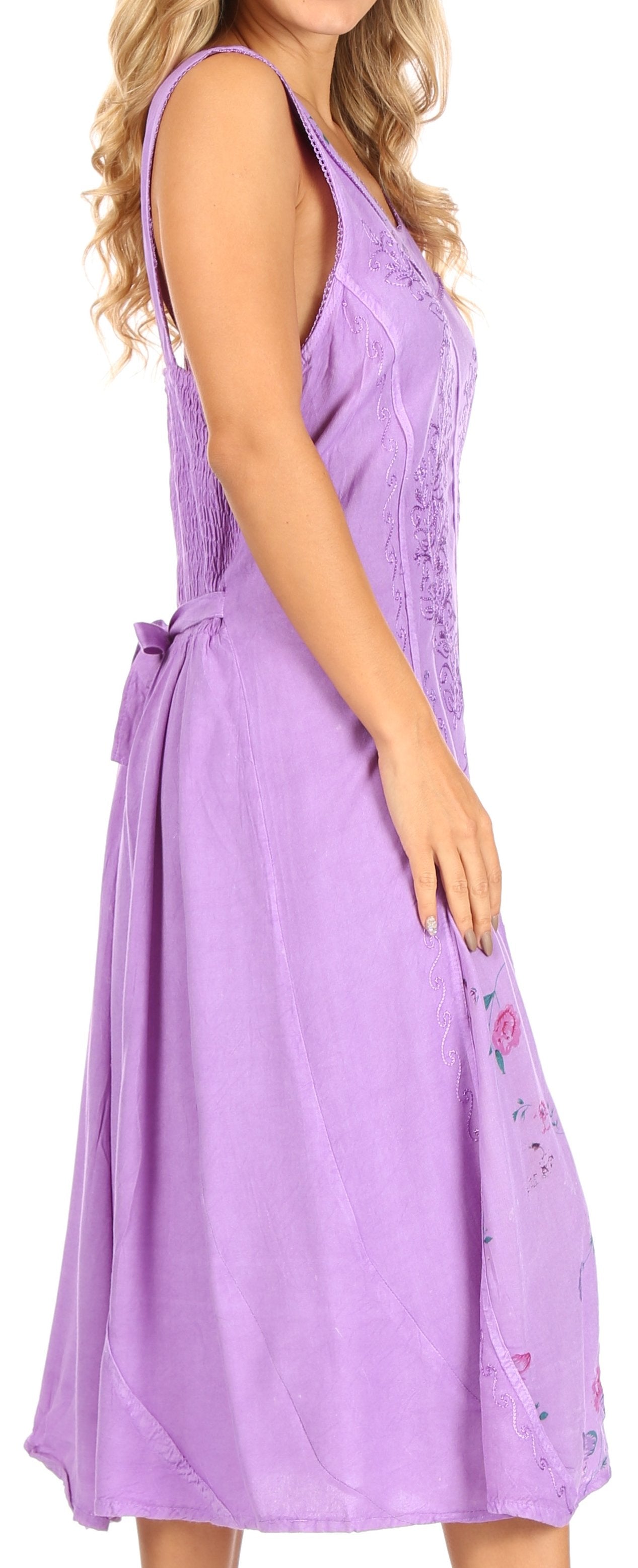 Woman wearing a purple sleeveless dress with floral details on a white background