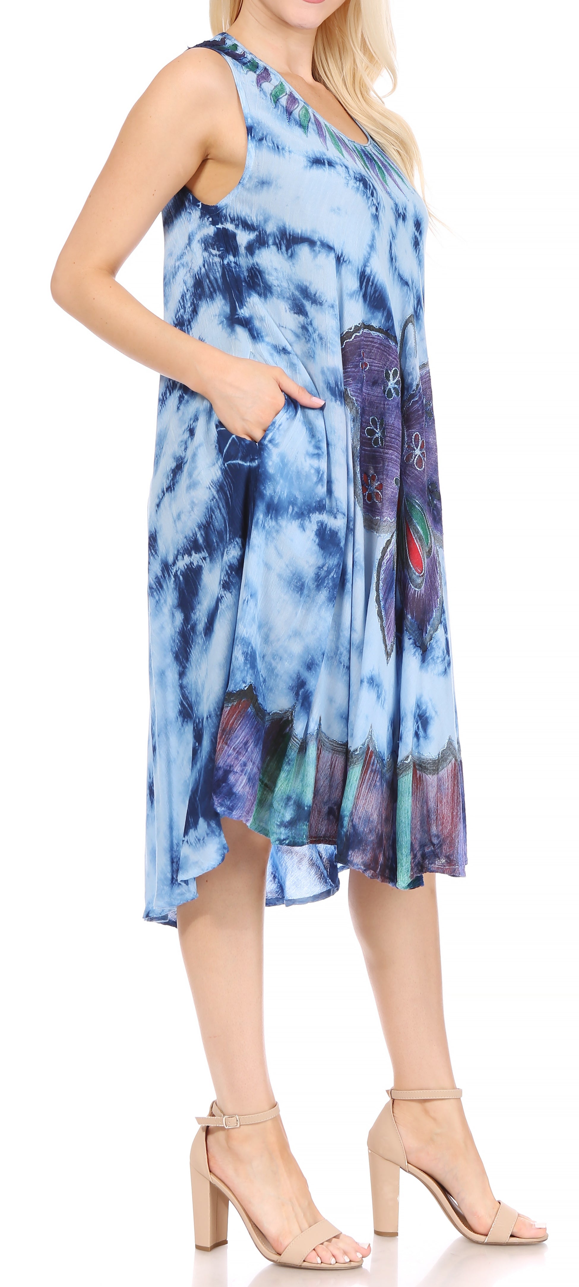 Woman wearing a blue tie-dye dress with floral patterns on a white background