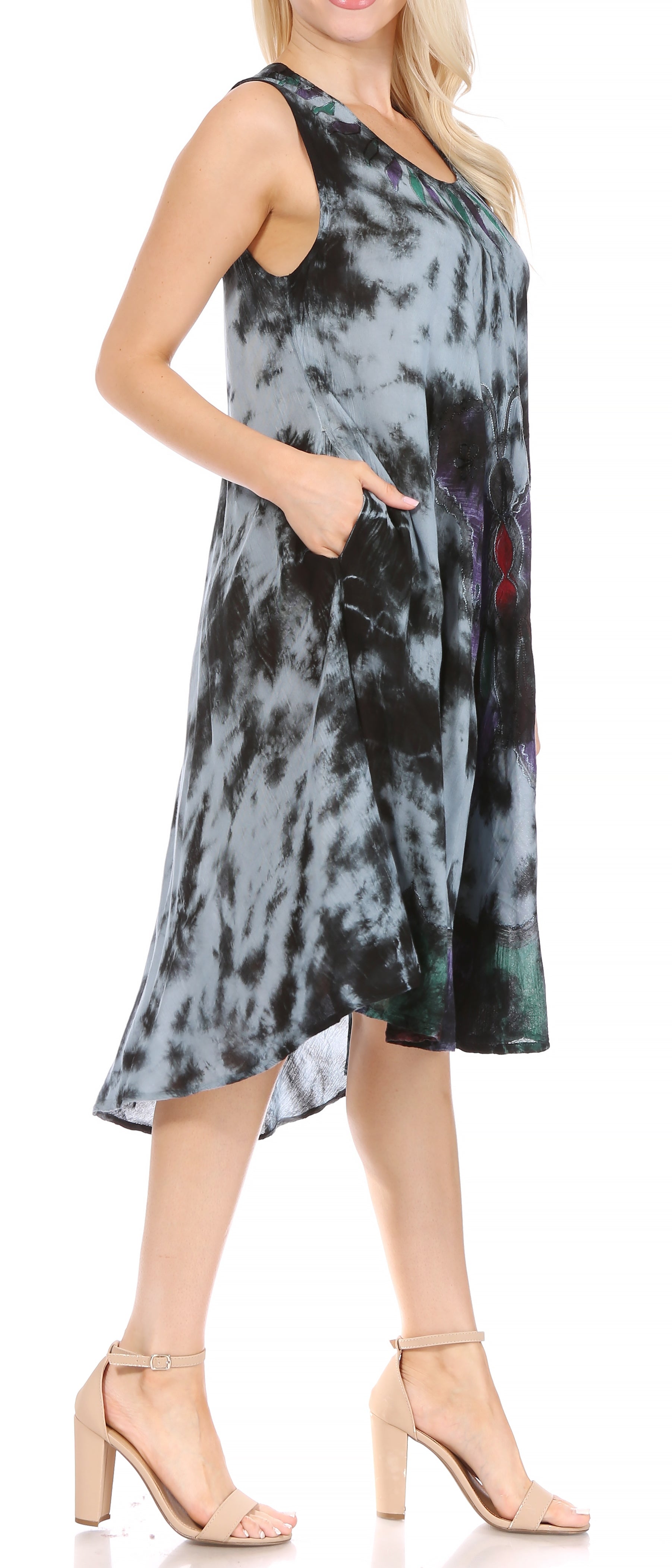 Woman wearing a sleeveless tie-dye dress with a high-low hemline.