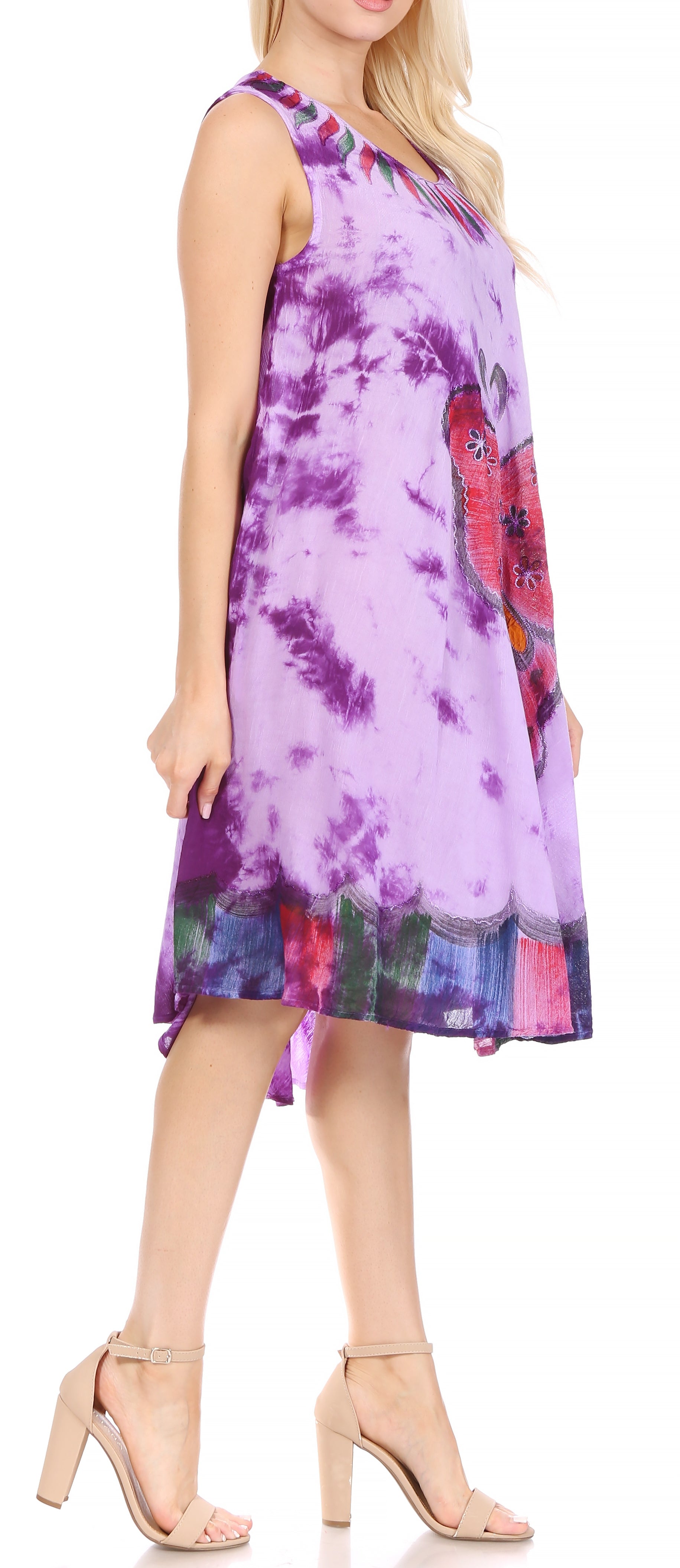 Woman wearing a sleeveless tie-dye dress with floral pattern on a plain background