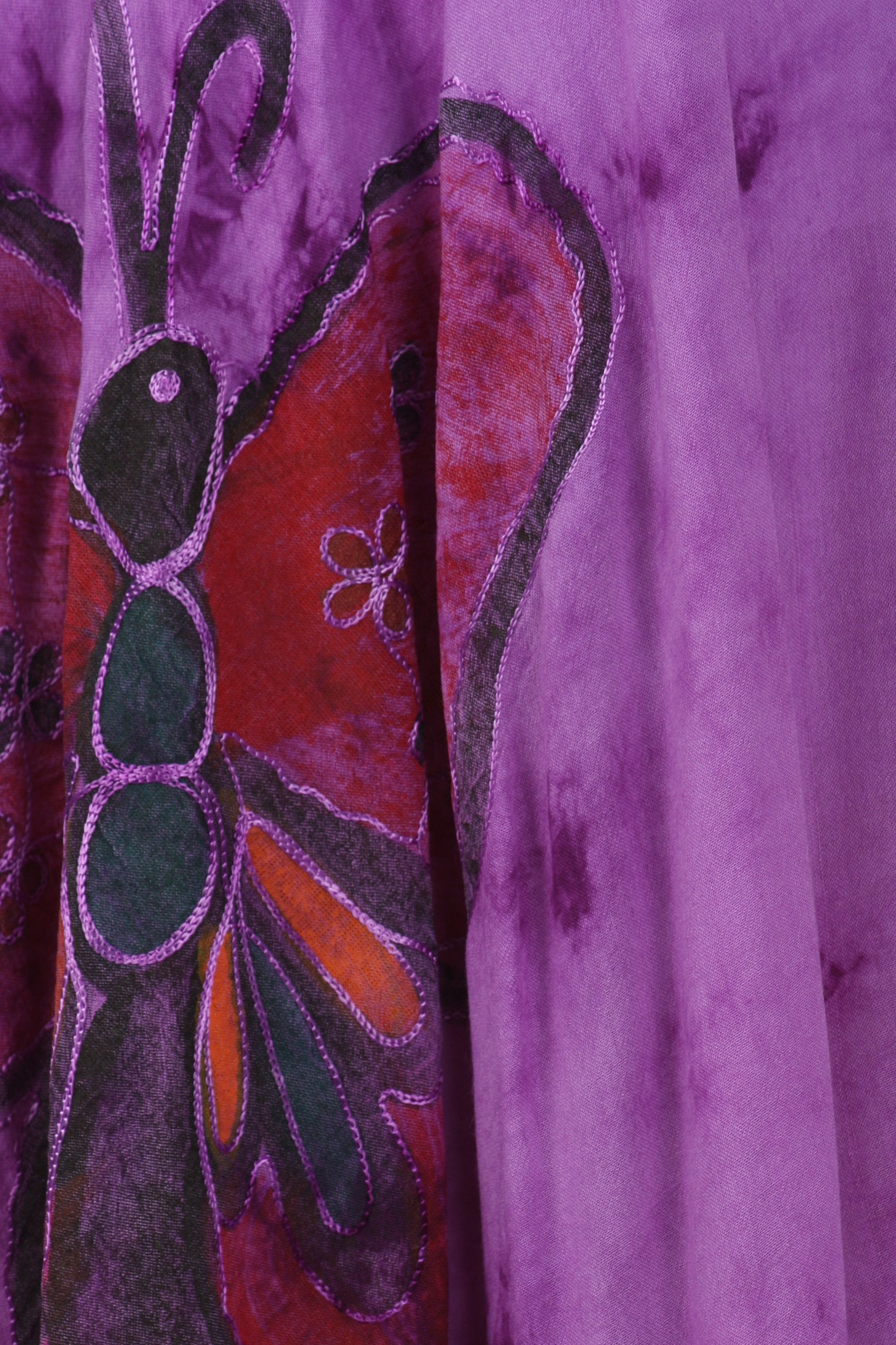 Close-up of a colorful butterfly design on a purple fabric background