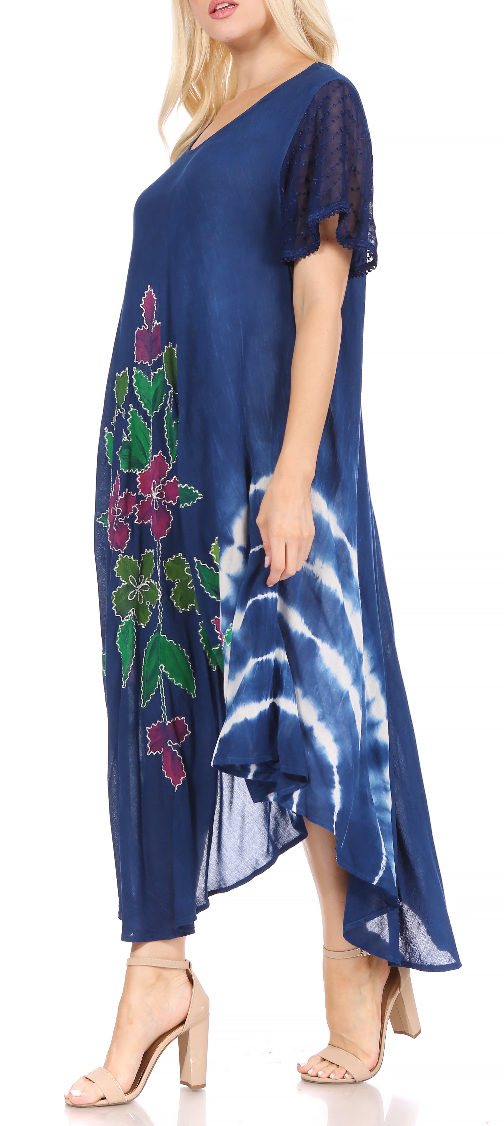 Woman wearing a blue dress with floral embroidery and tie-dye pattern.
