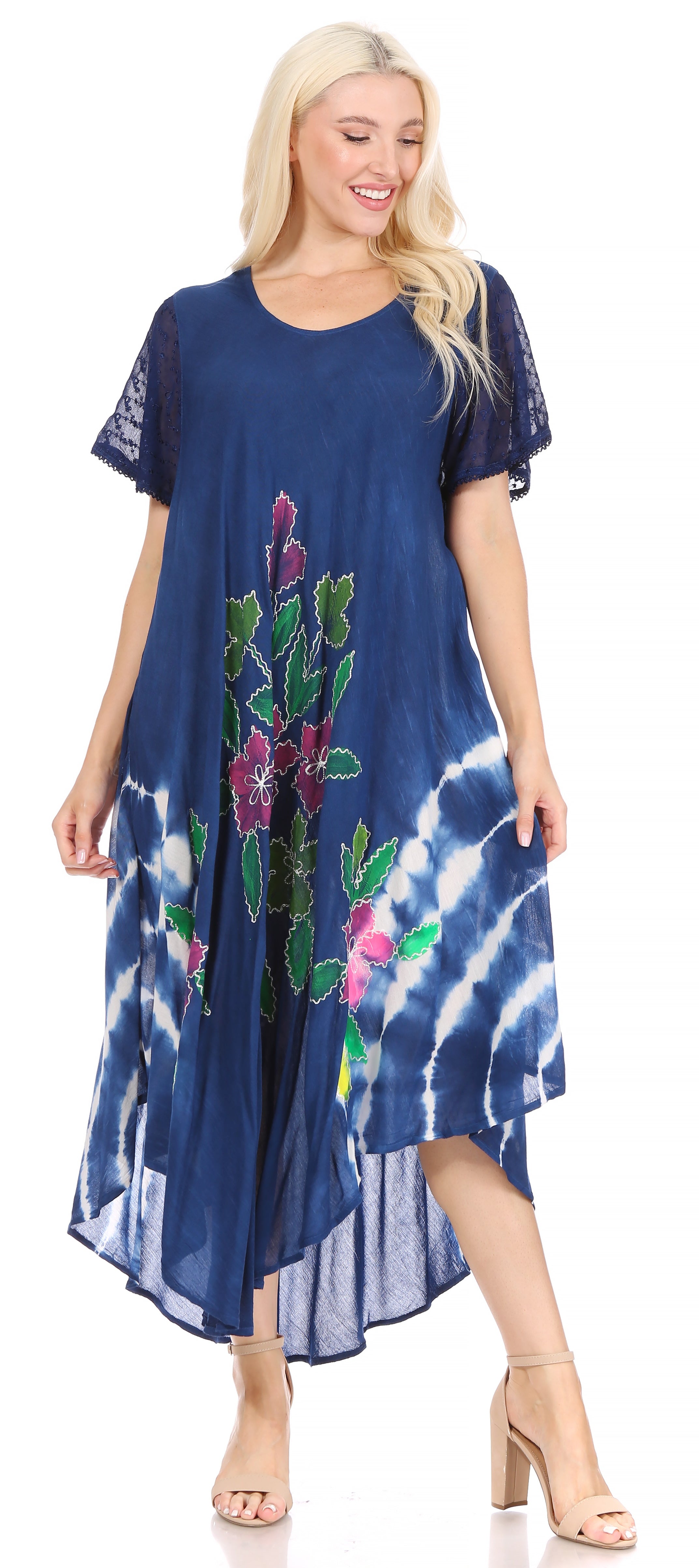 Woman wearing a blue dress with floral embroidery and tie-dye pattern on a white background