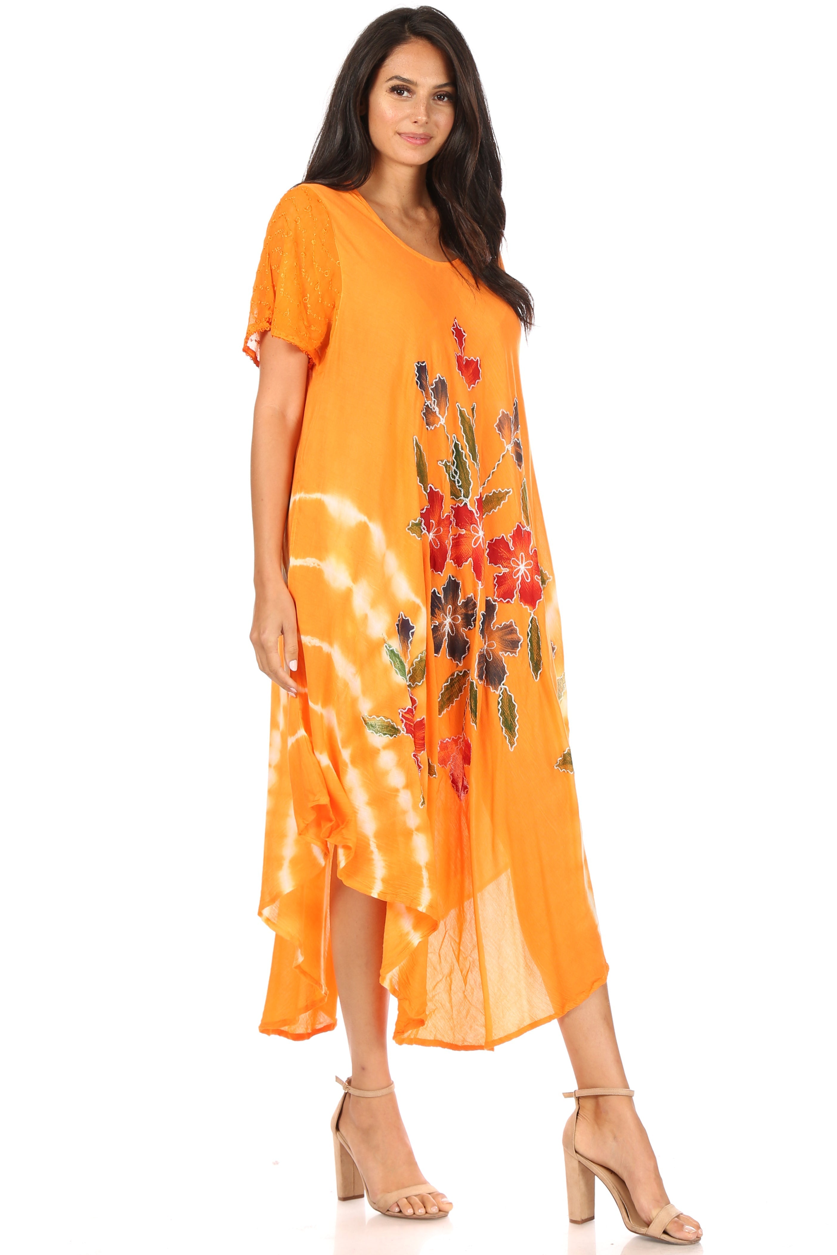 Woman wearing an orange dress with floral patterns on a white background