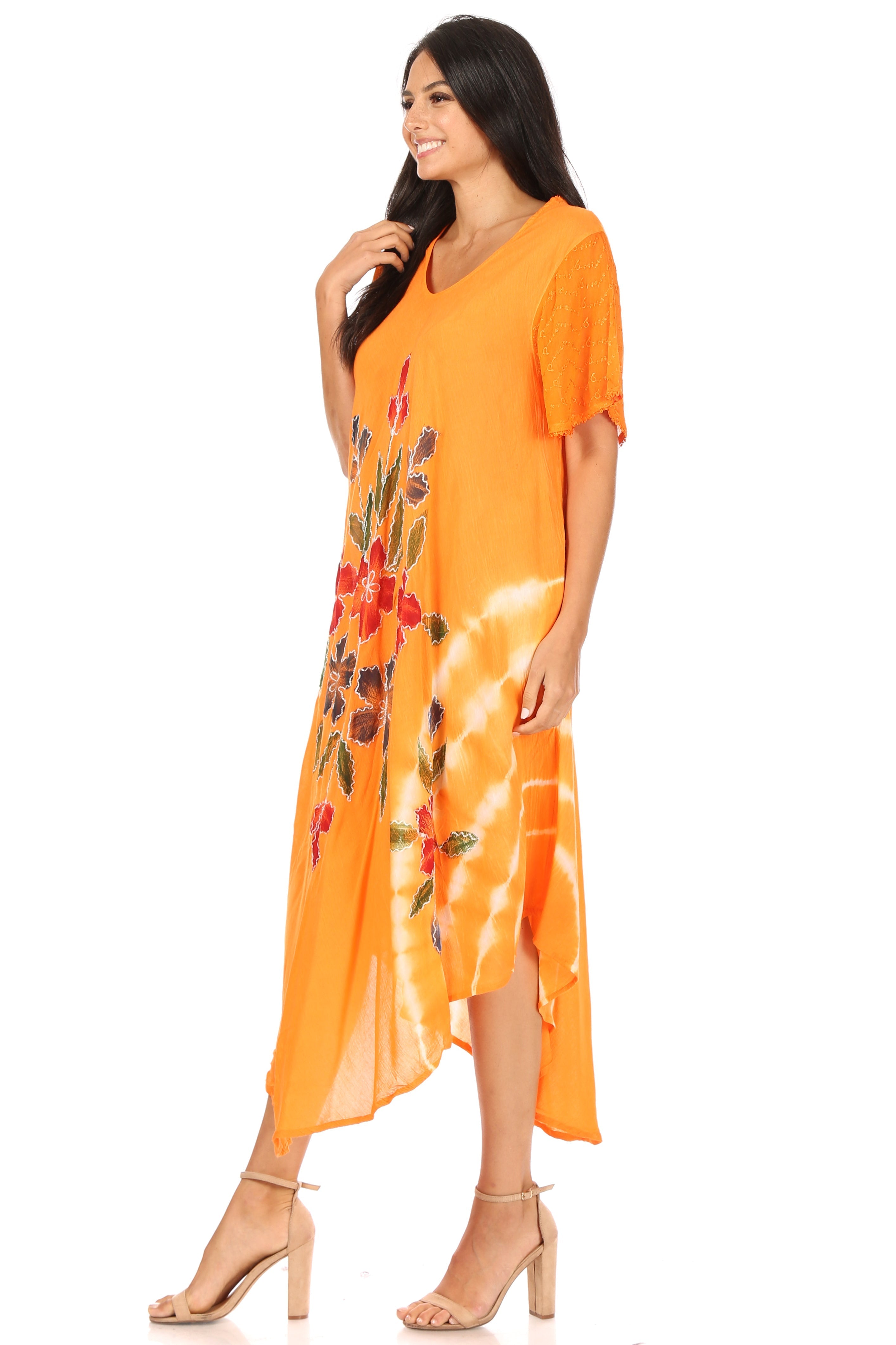 Woman wearing an orange dress with floral patterns on a white background