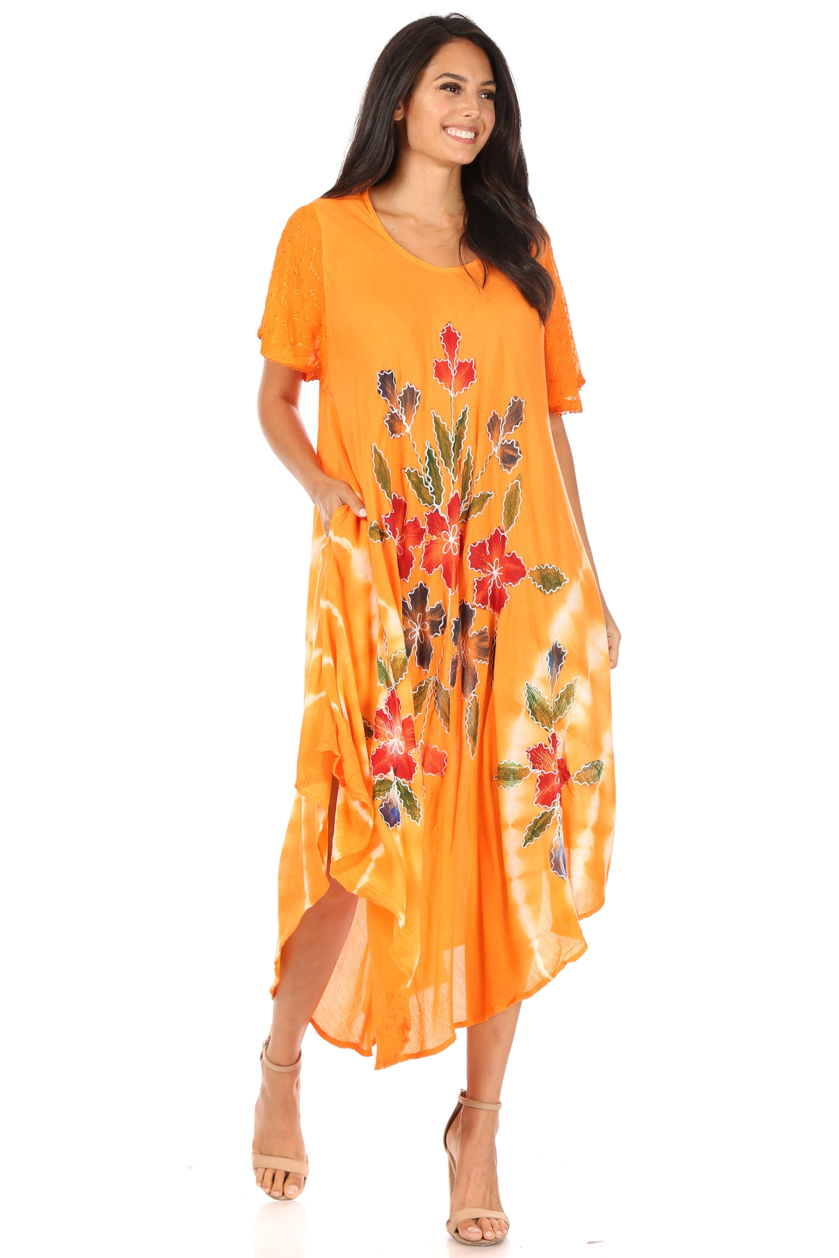 Woman wearing an orange dress with floral patterns on a white background