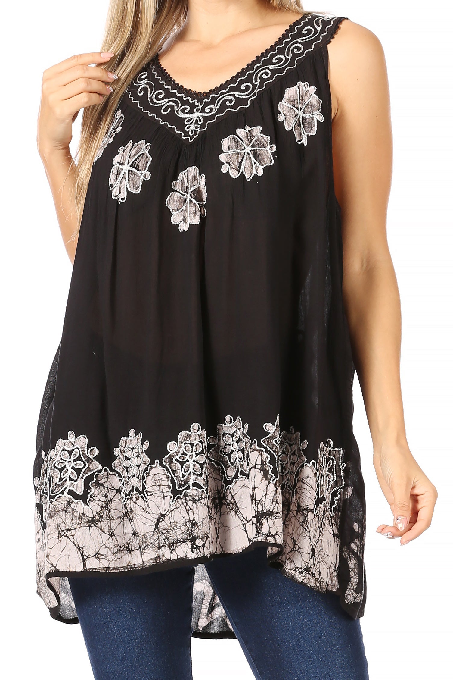 Black sleeveless top with white floral embroidery worn by a person on a white background