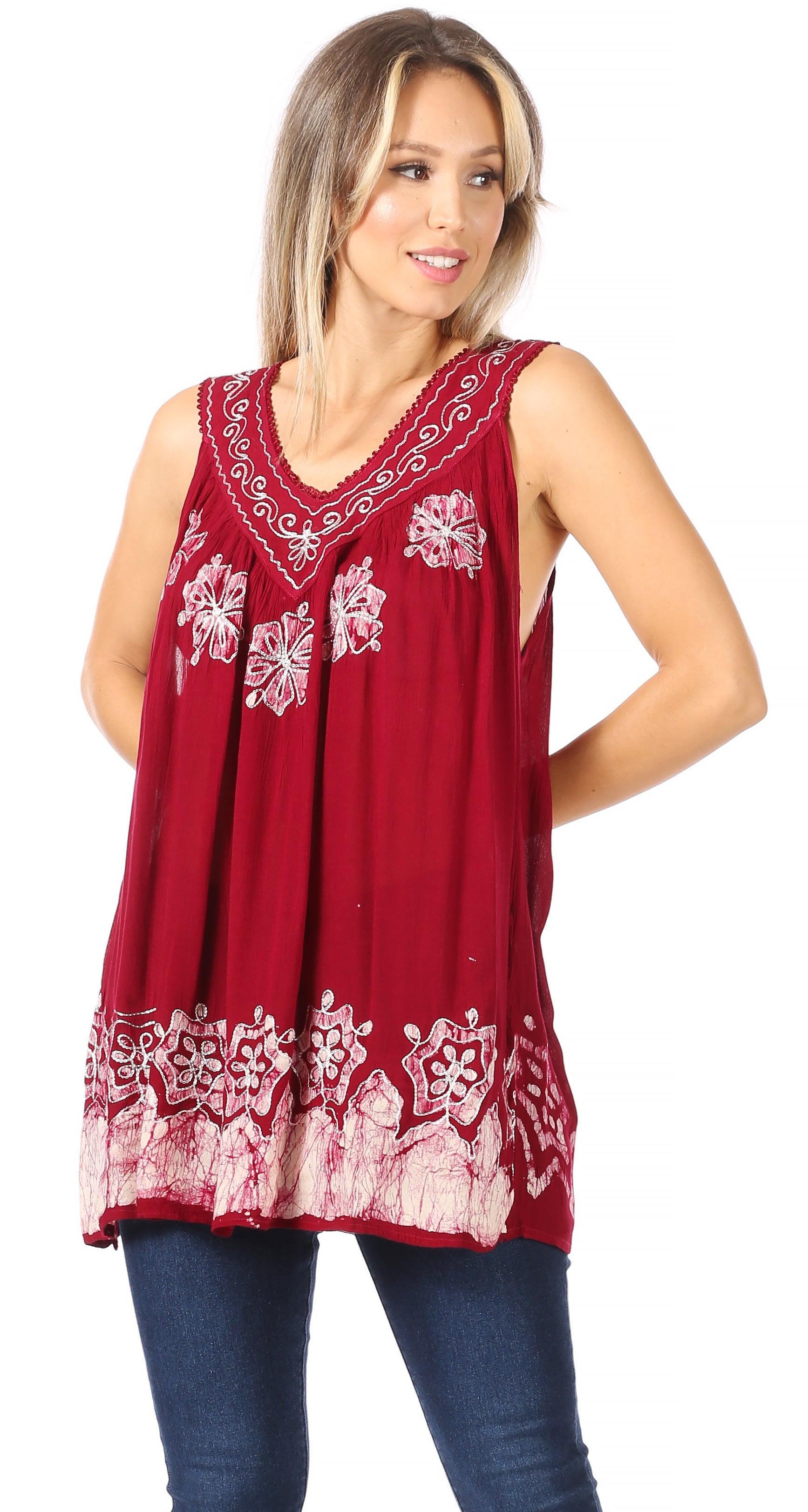 Woman wearing a red sleeveless top with white floral embroidery on a white background