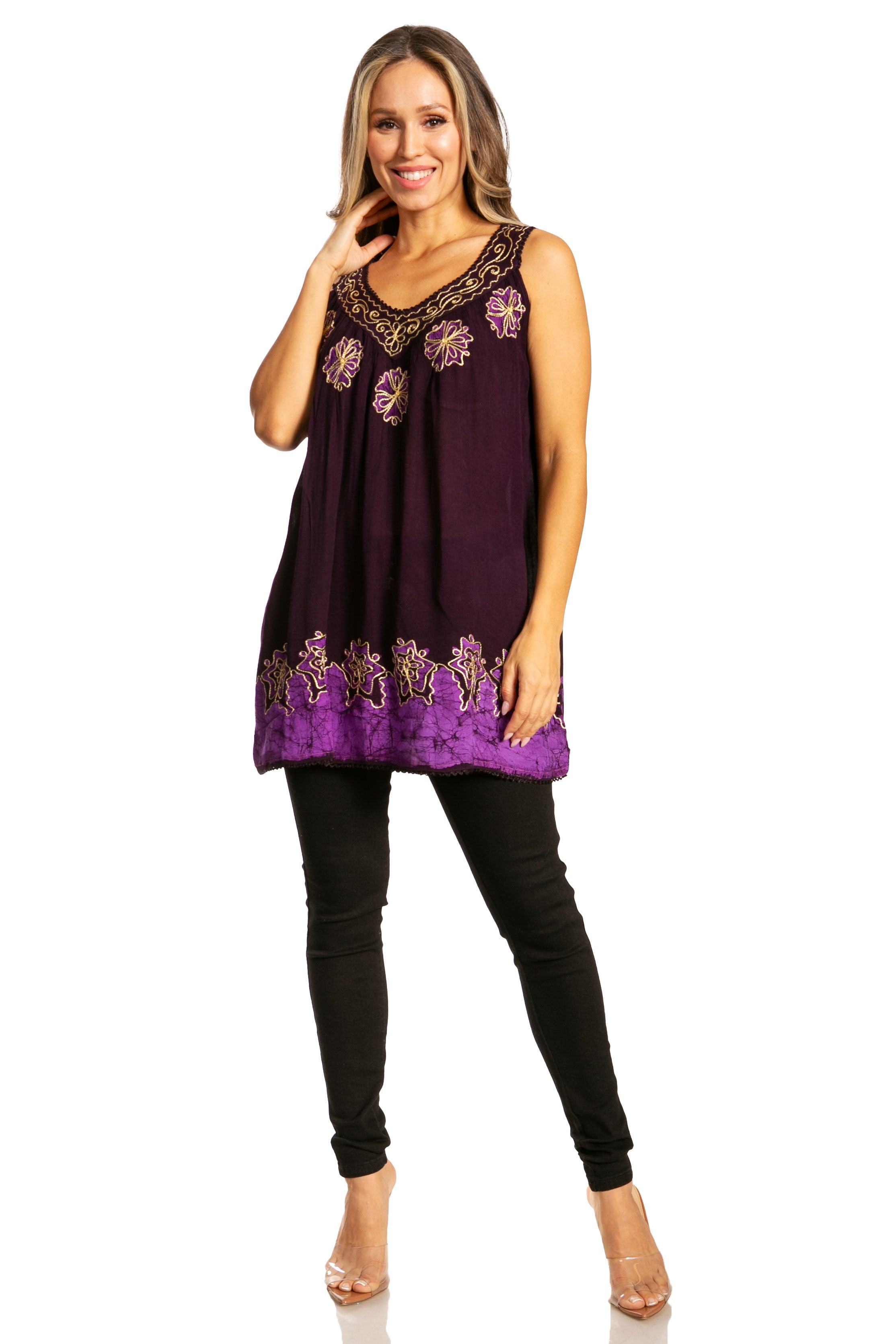 Woman wearing a purple sleeveless top with embroidery and black leggings on a white background