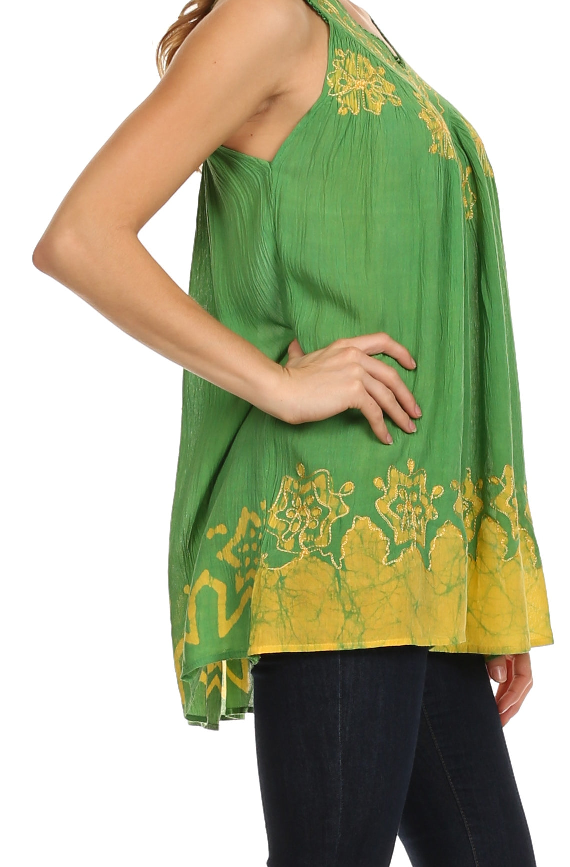 Green embroidered top with yellow patterns worn by a person on a white background