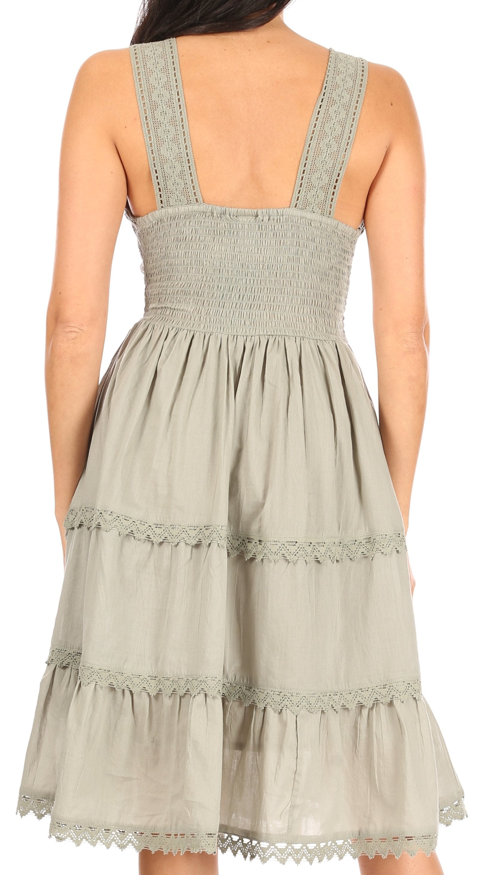 Light green dress with smocked bodice and lace trim on a white background