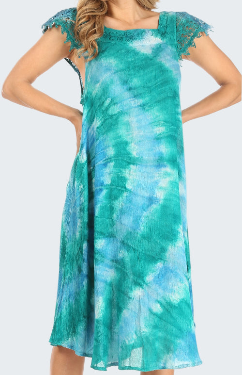 Woman wearing a teal and blue tie-dye dress with lace sleeves on a white background