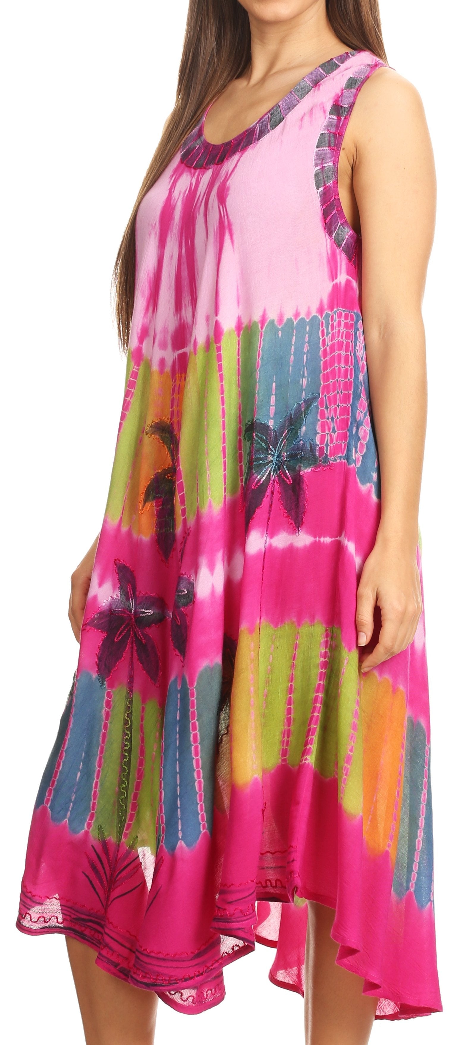 Woman wearing a colorful tie-dye dress with floral patterns on a plain background