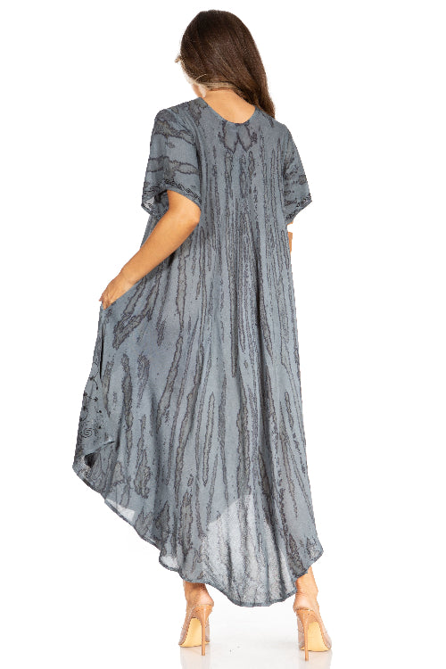 Woman wearing a long, patterned gray dress on a white background