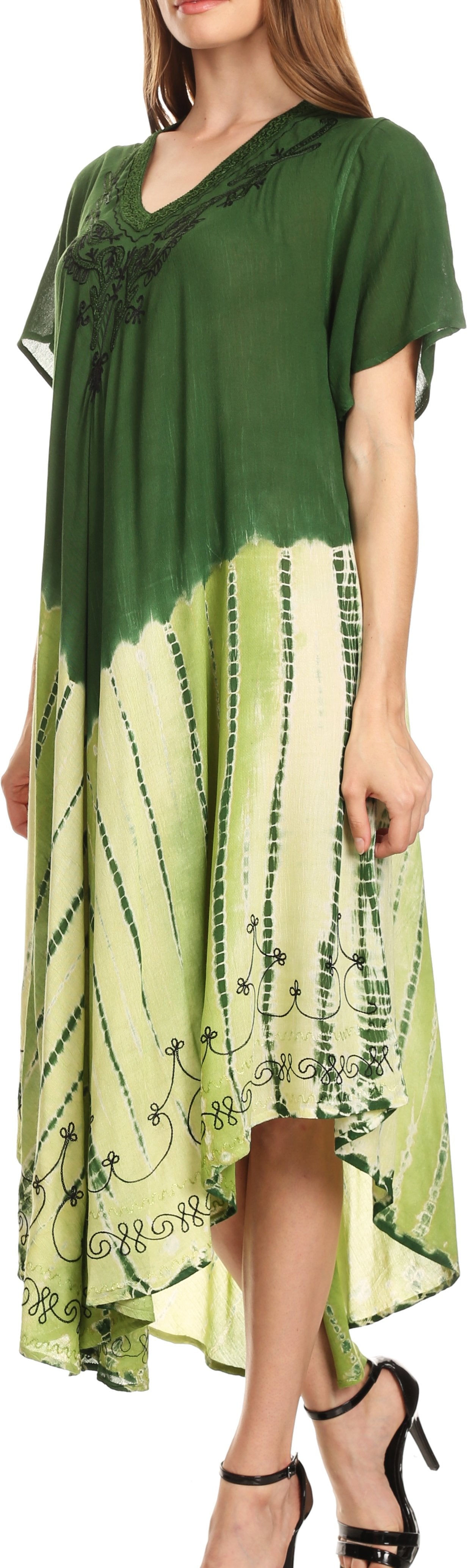 Woman wearing a green and white patterned dress with sheer sleeves.
