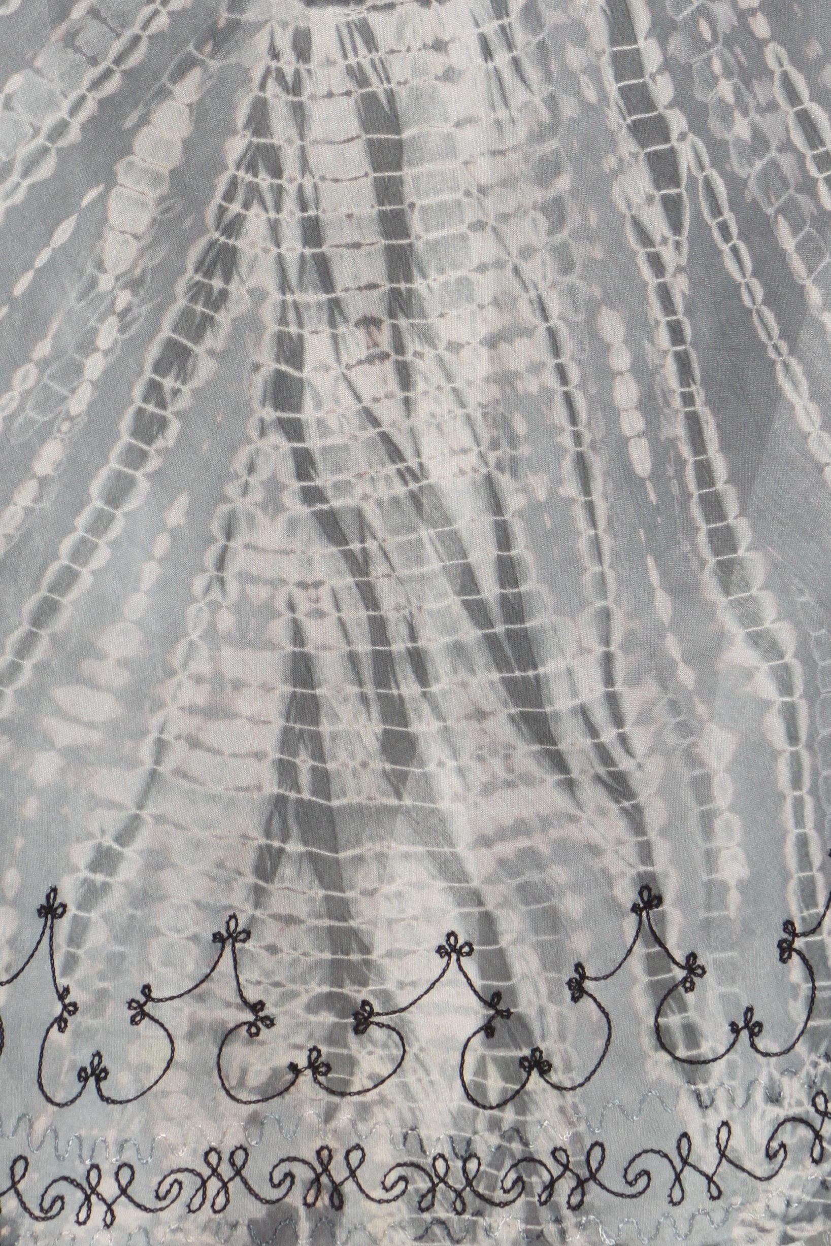 Textured gray fabric with decorative black trim at the bottom