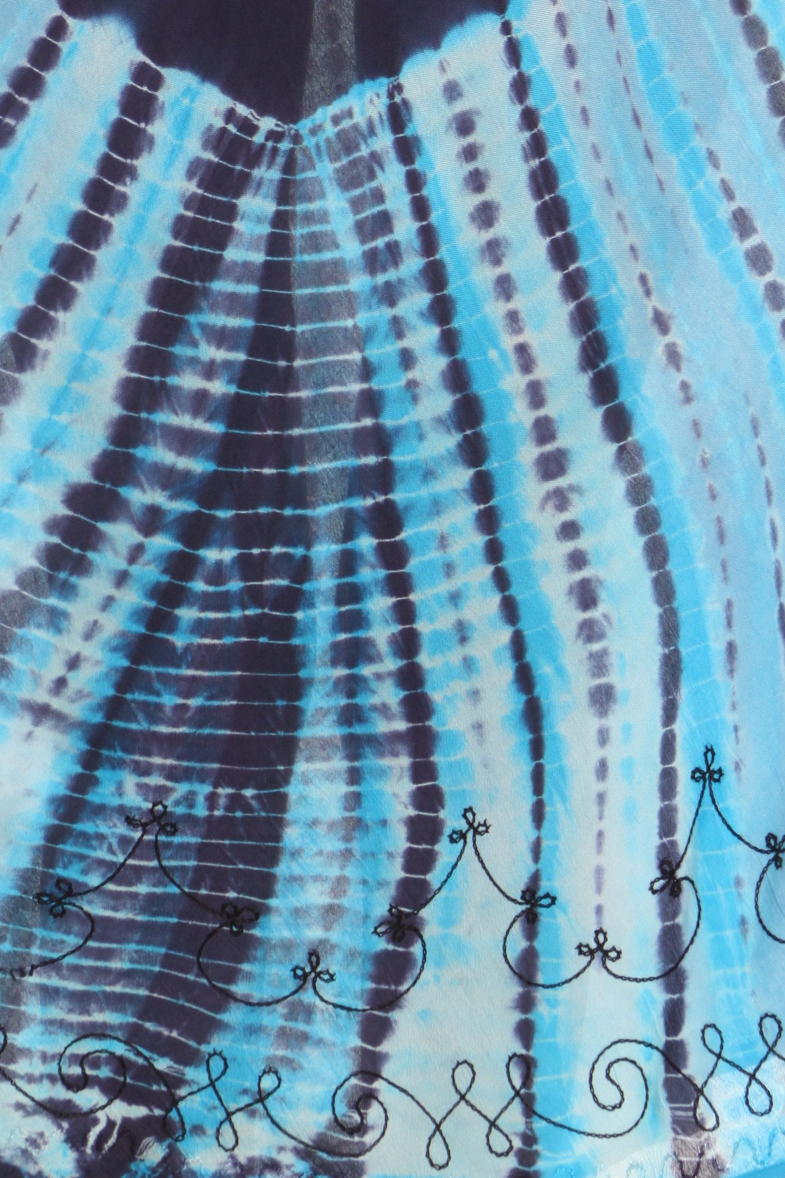 Close-up of a tie-dye pattern with blue and black colors on a fabric background.