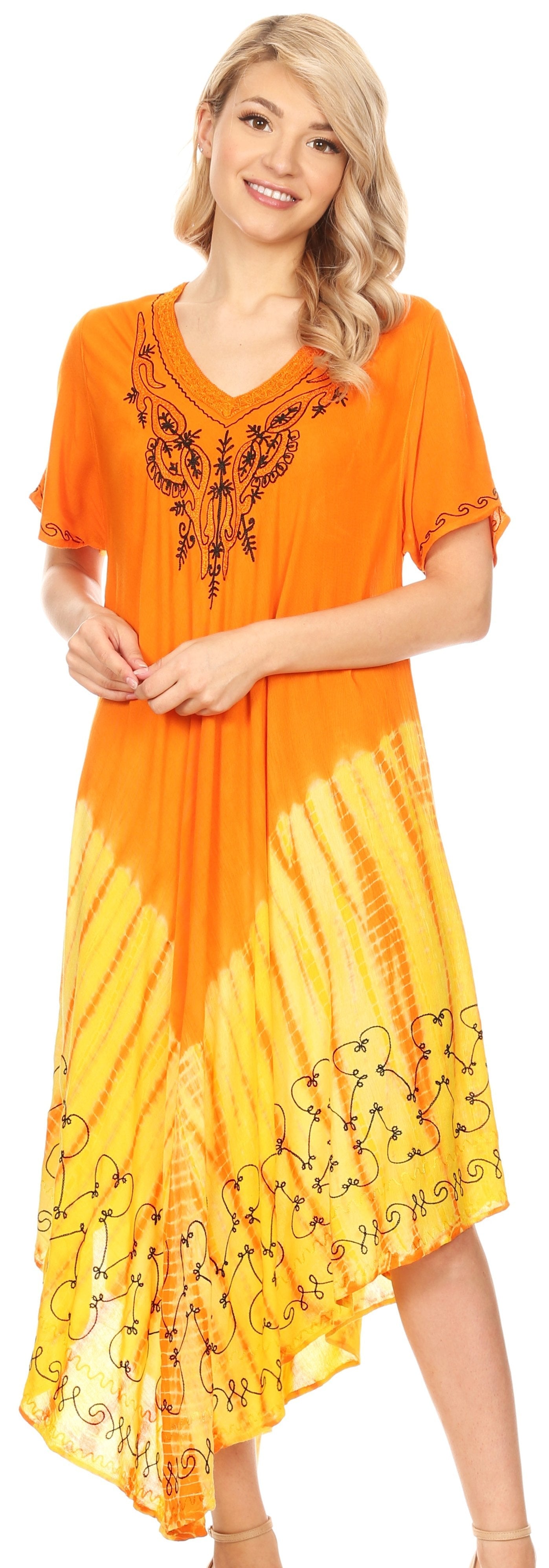 Woman wearing an orange and yellow dress with embroidery, standing against a white background.