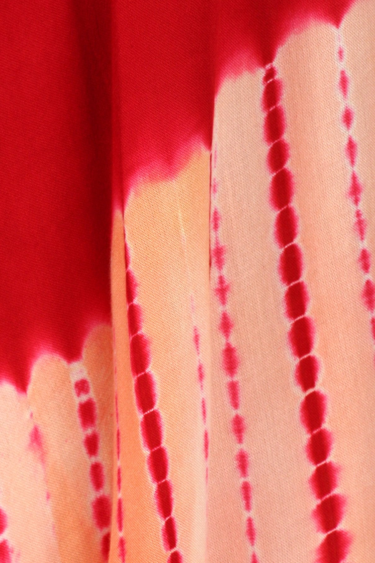Close-up of a tie-dye pattern with red and beige colors.