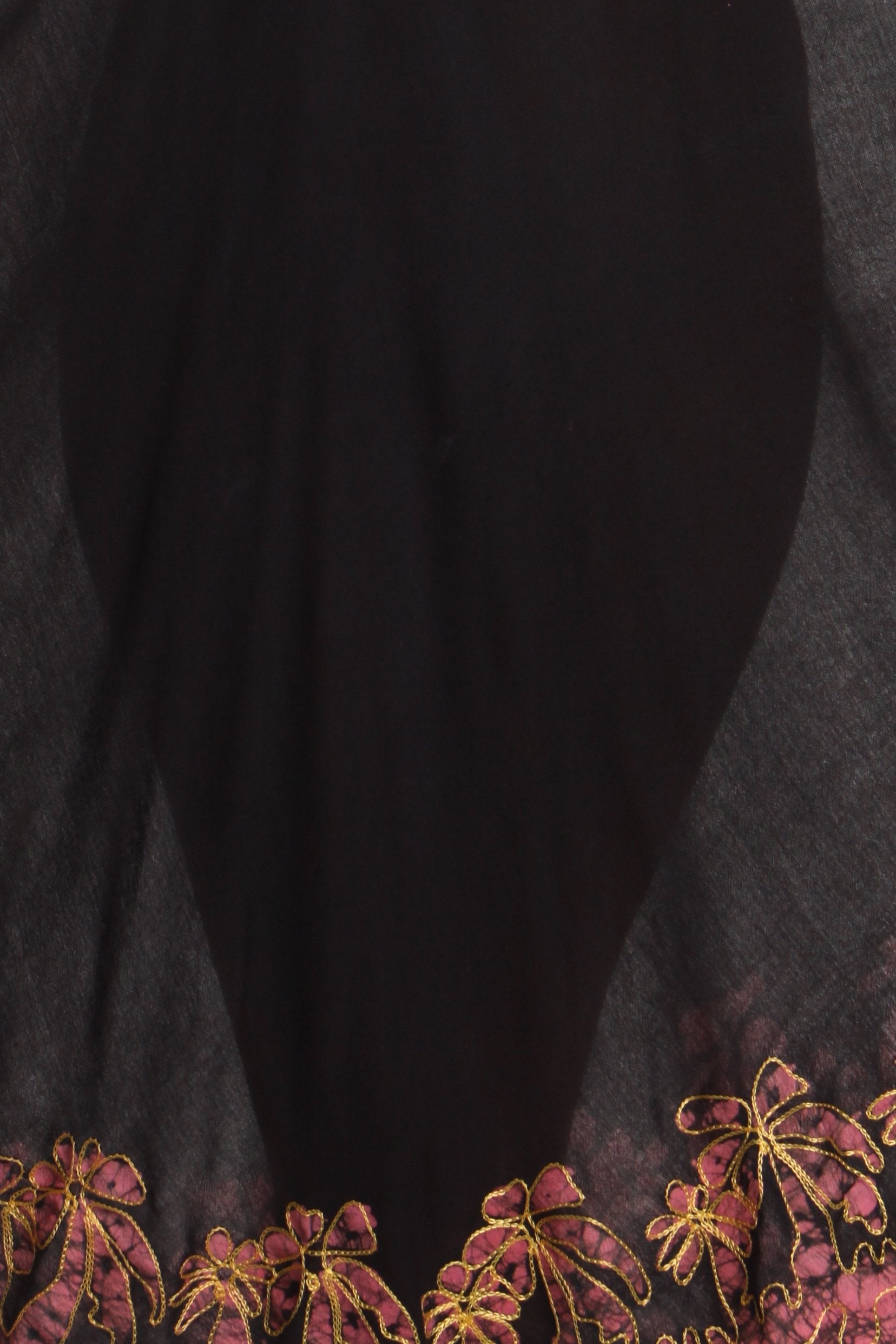 Black fabric with floral embroidery on a textured surface