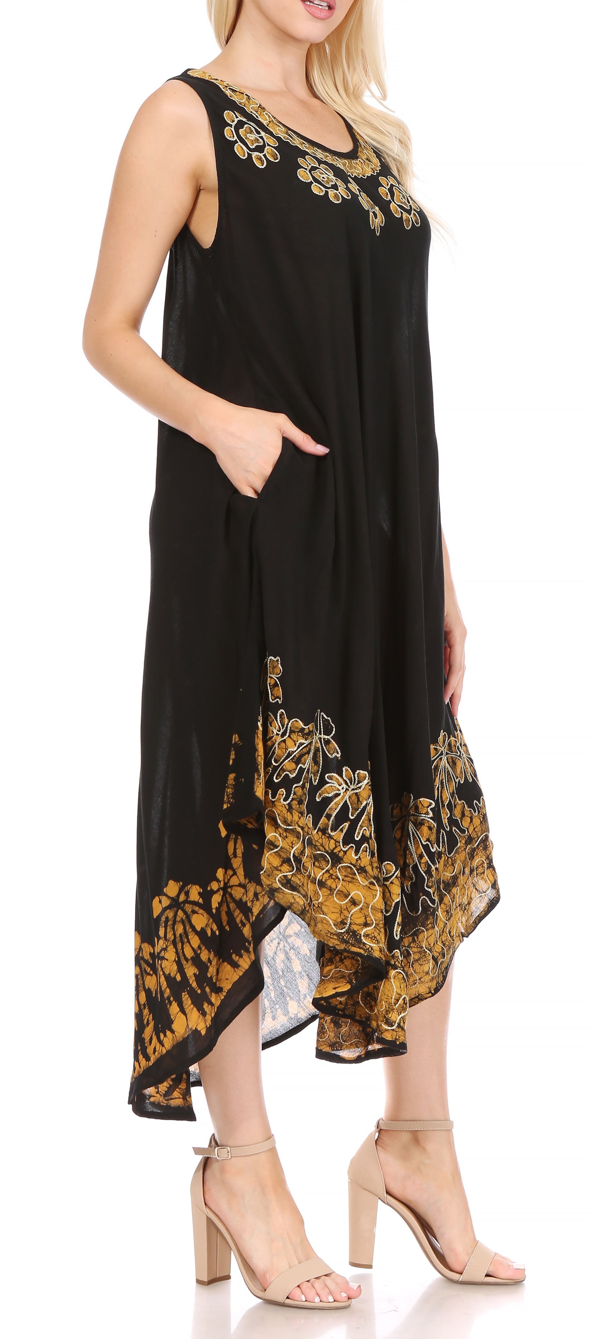 Black dress with gold embroidery worn by a model on a white background