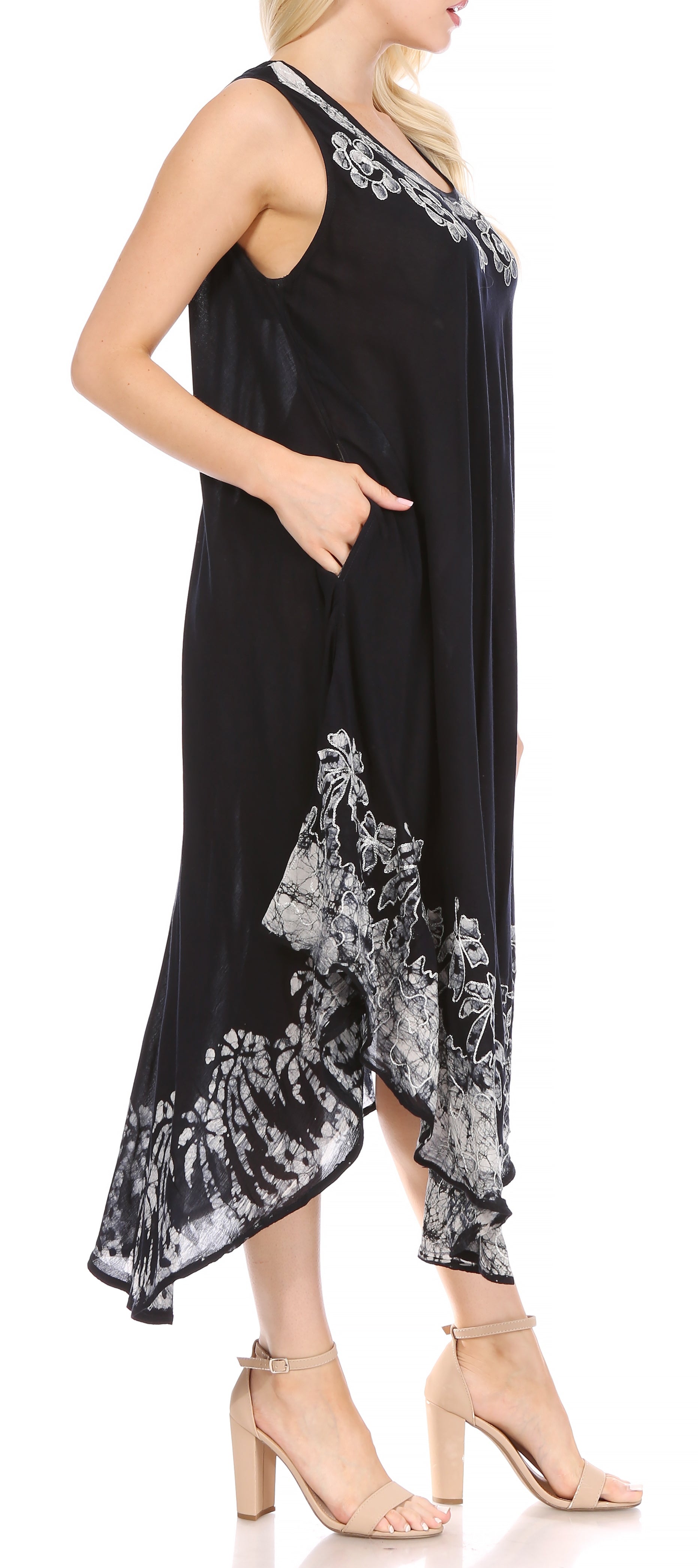 Black dress with floral patterns worn by a model on a white background
