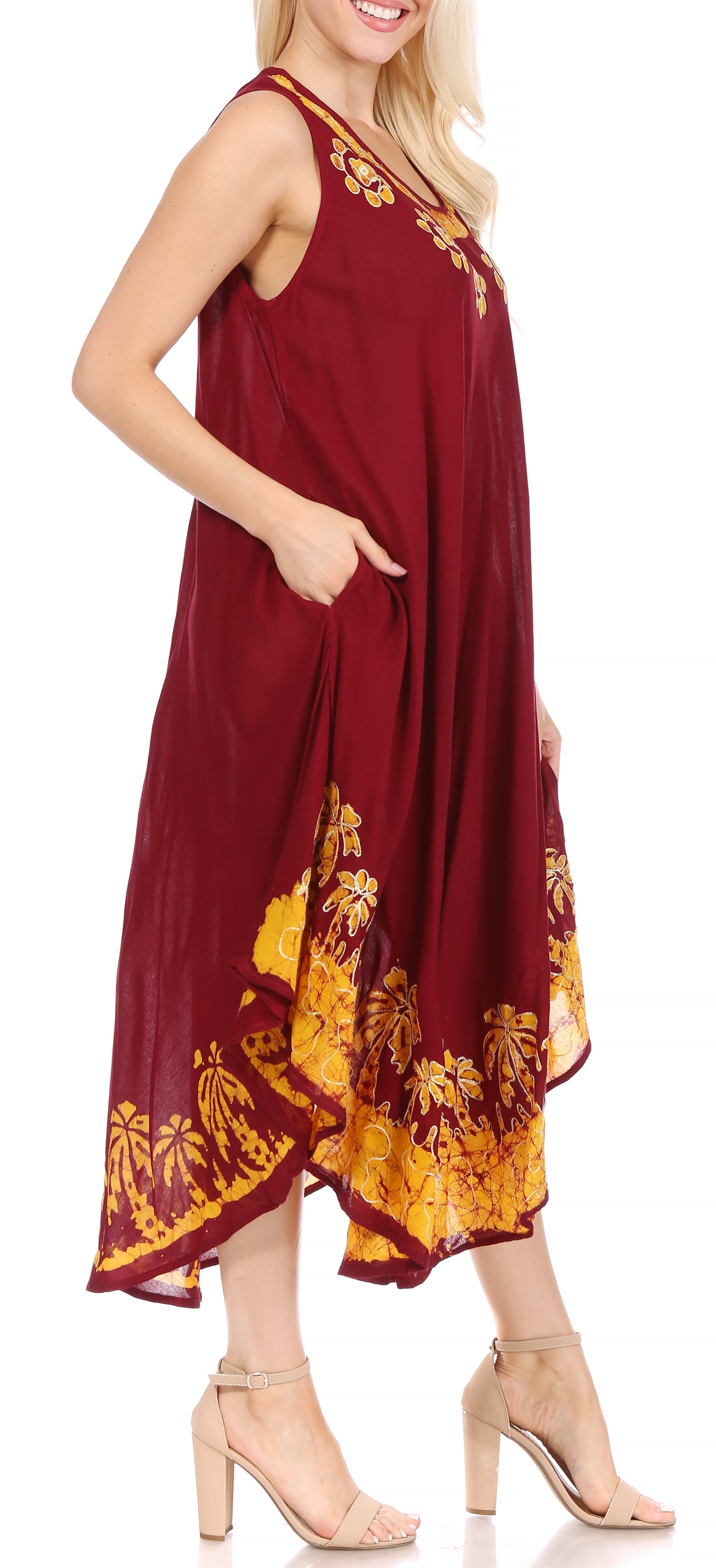 Woman wearing a burgundy dress with yellow floral patterns on a white background