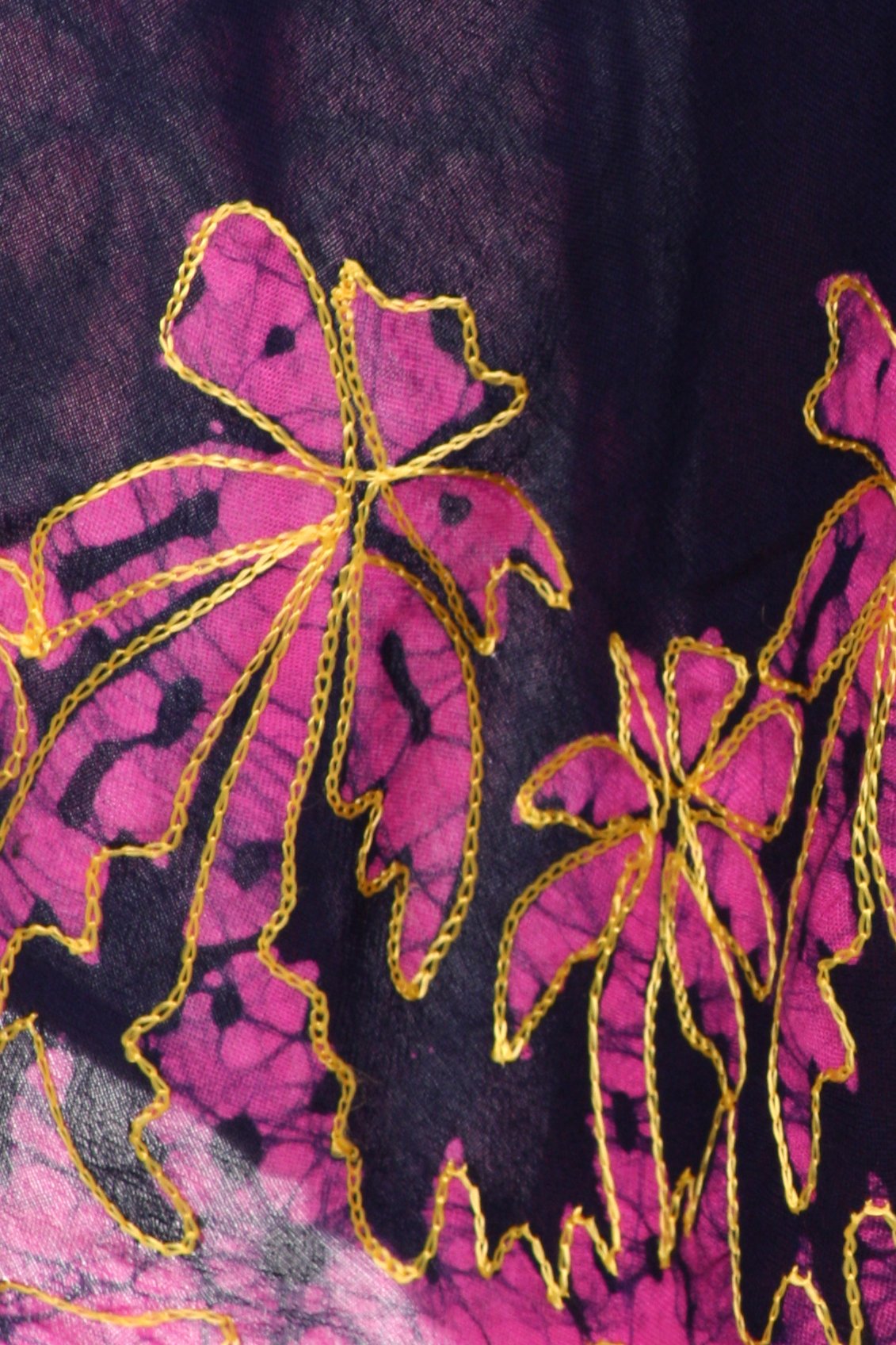 Close-up of pink floral embroidery with gold outlines on a dark fabric background