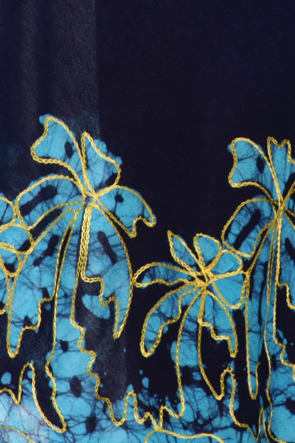 Close-up of blue and gold floral embroidery on a dark fabric background