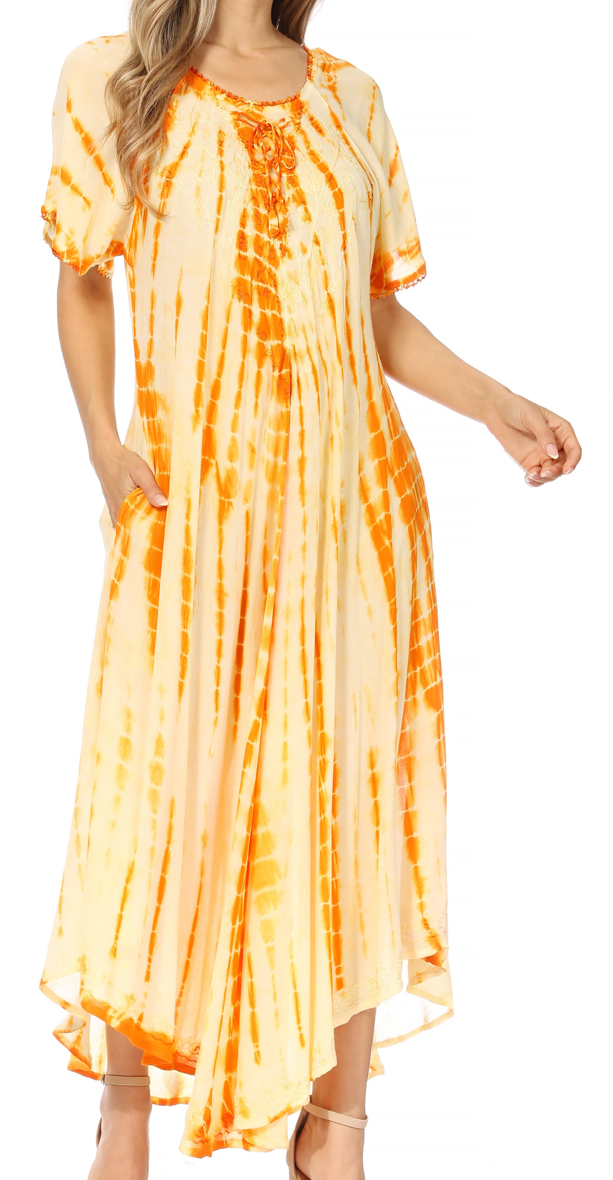 Woman wearing a tie-dye dress with orange and yellow pattern on a white background