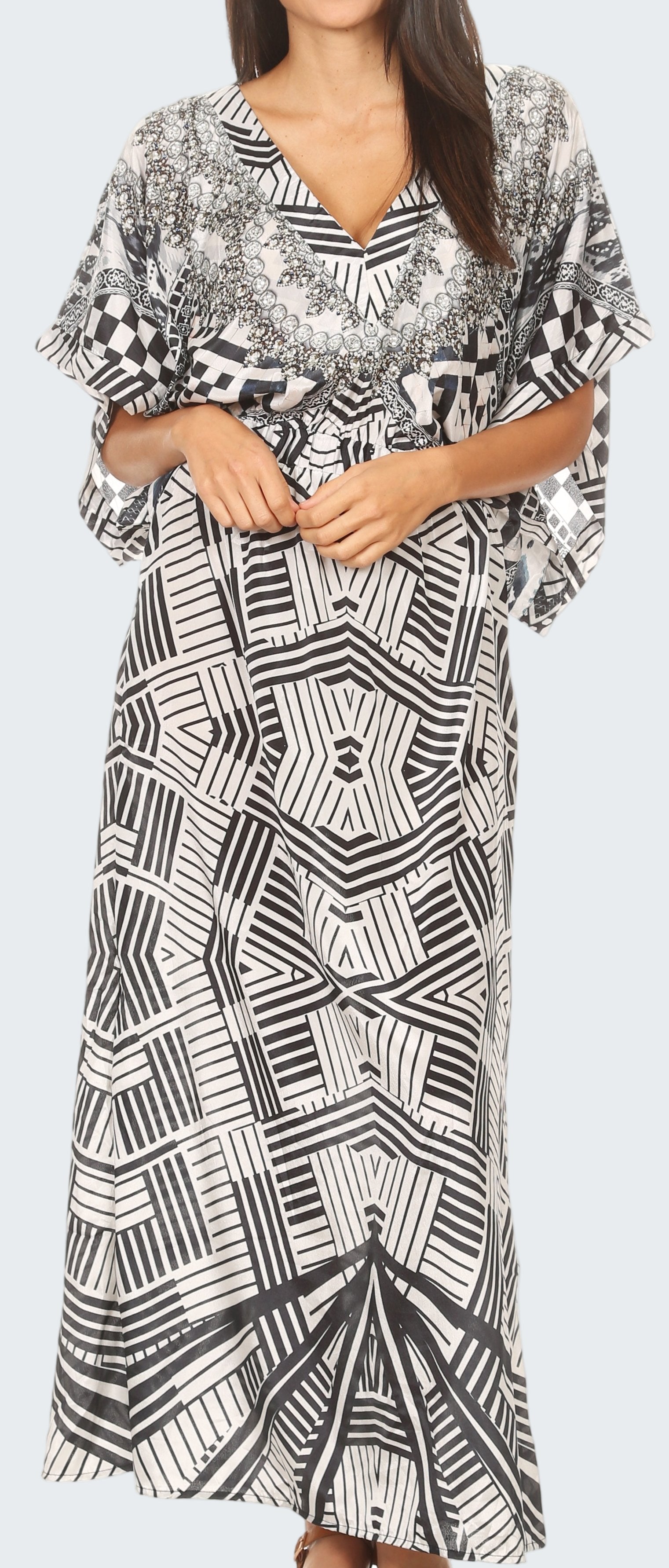 Woman wearing a black and white patterned dress with a plain background