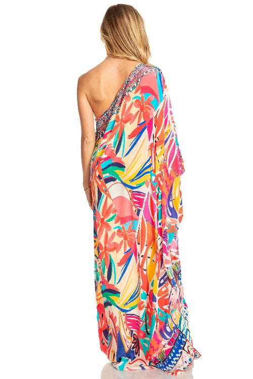 Woman wearing a colorful one-shoulder dress with a floral pattern on a white background