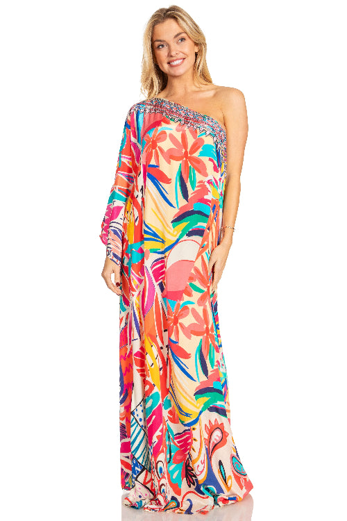Woman wearing a colorful floral one-shoulder dress on a white background