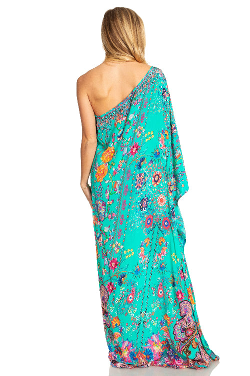 Woman wearing a colorful floral one-shoulder dress on a white background