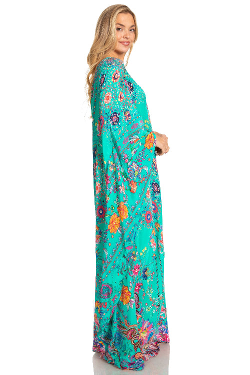 Woman wearing a teal floral dress on a white background