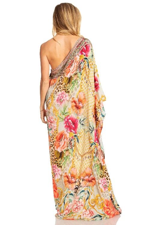 Woman wearing a colorful floral and animal print dress on a white background