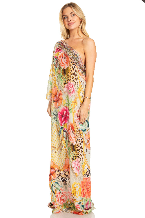 Woman wearing a floral and leopard print one-shoulder dress on a white background