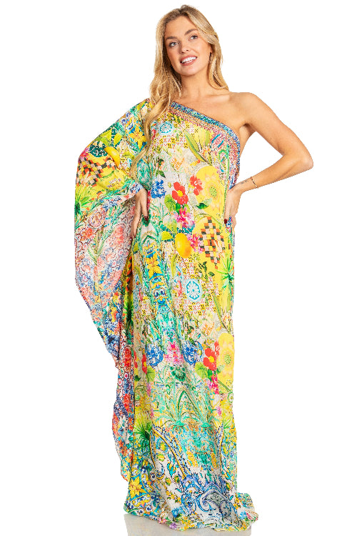 Woman wearing a colorful floral one-shoulder dress on a white background