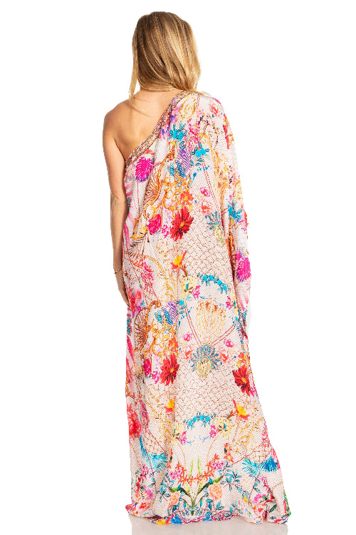 Woman wearing a colorful floral one-shoulder dress on a white background
