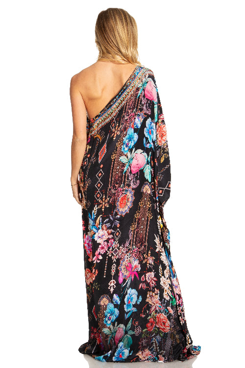 Woman wearing a floral one-shoulder dress on a white background