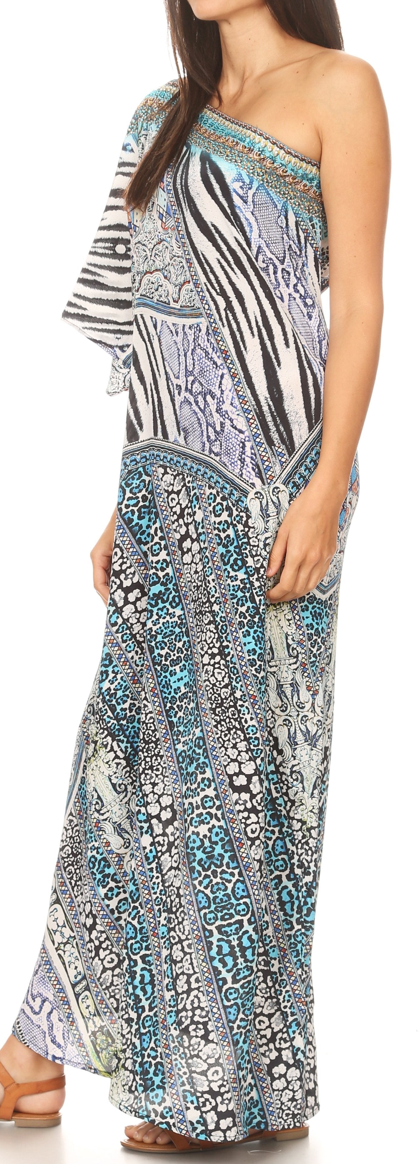 Woman wearing a patterned one-shoulder dress with a blue and white design.