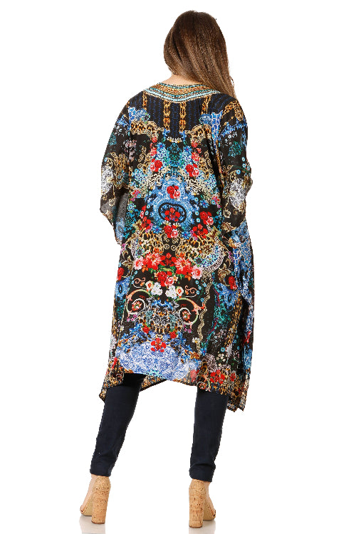 Woman wearing a colorful floral and paisley patterned dress on a white background