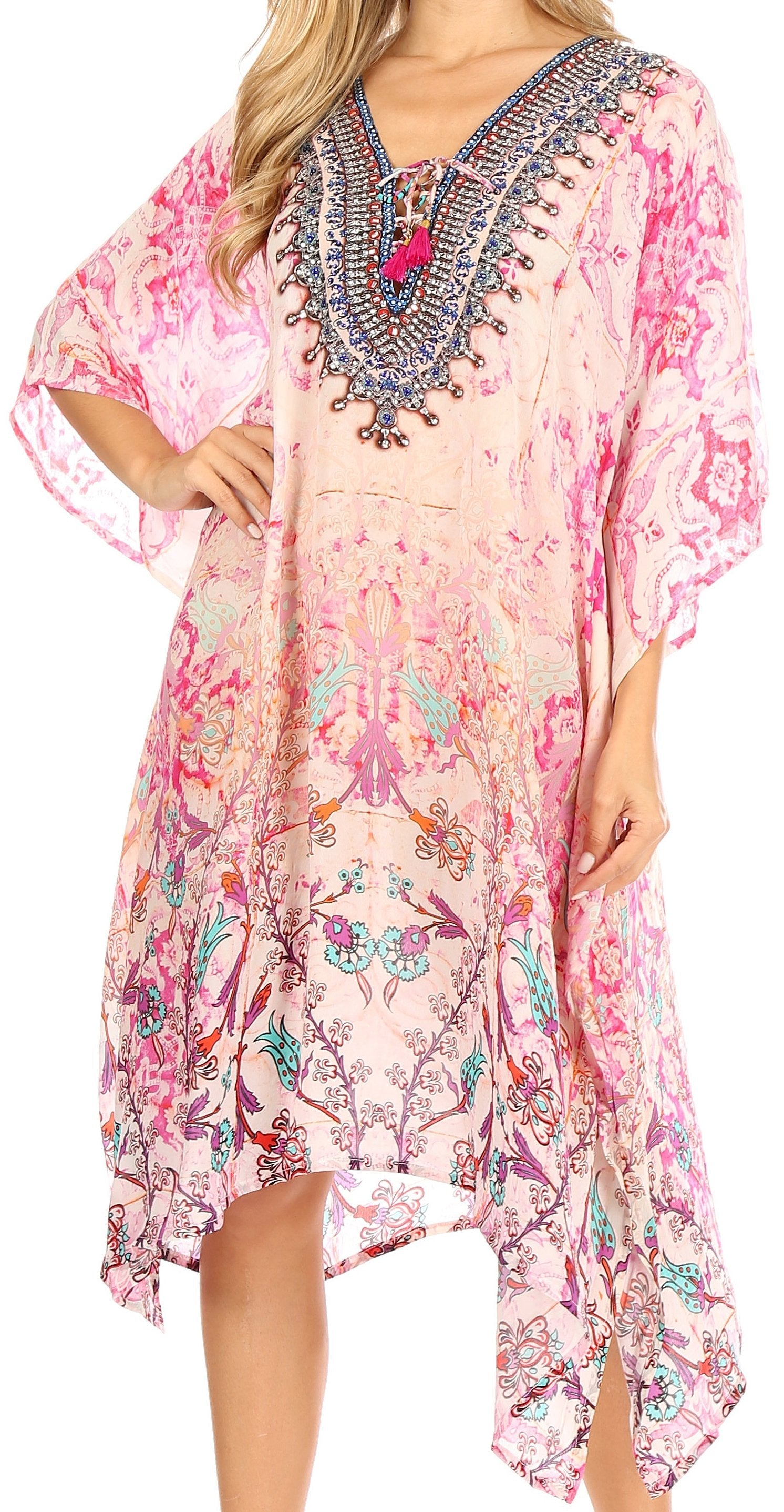 Woman wearing a pink floral dress with intricate embroidery on a white background