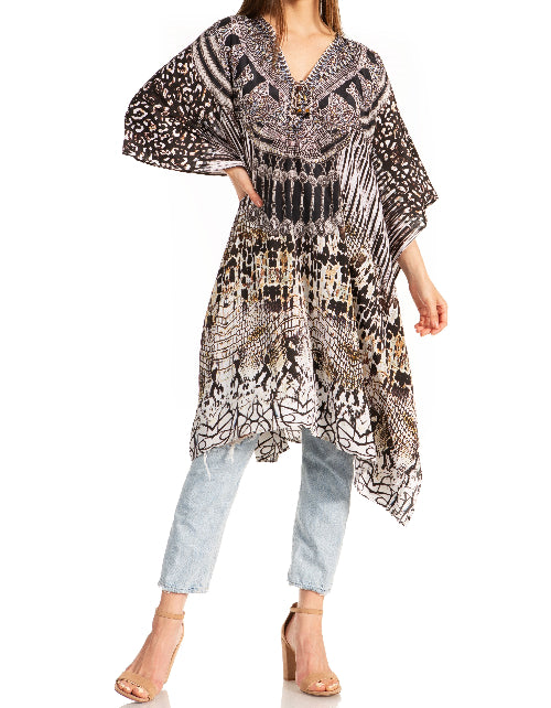 Woman wearing a patterned kaftan over light blue jeans on a white background
