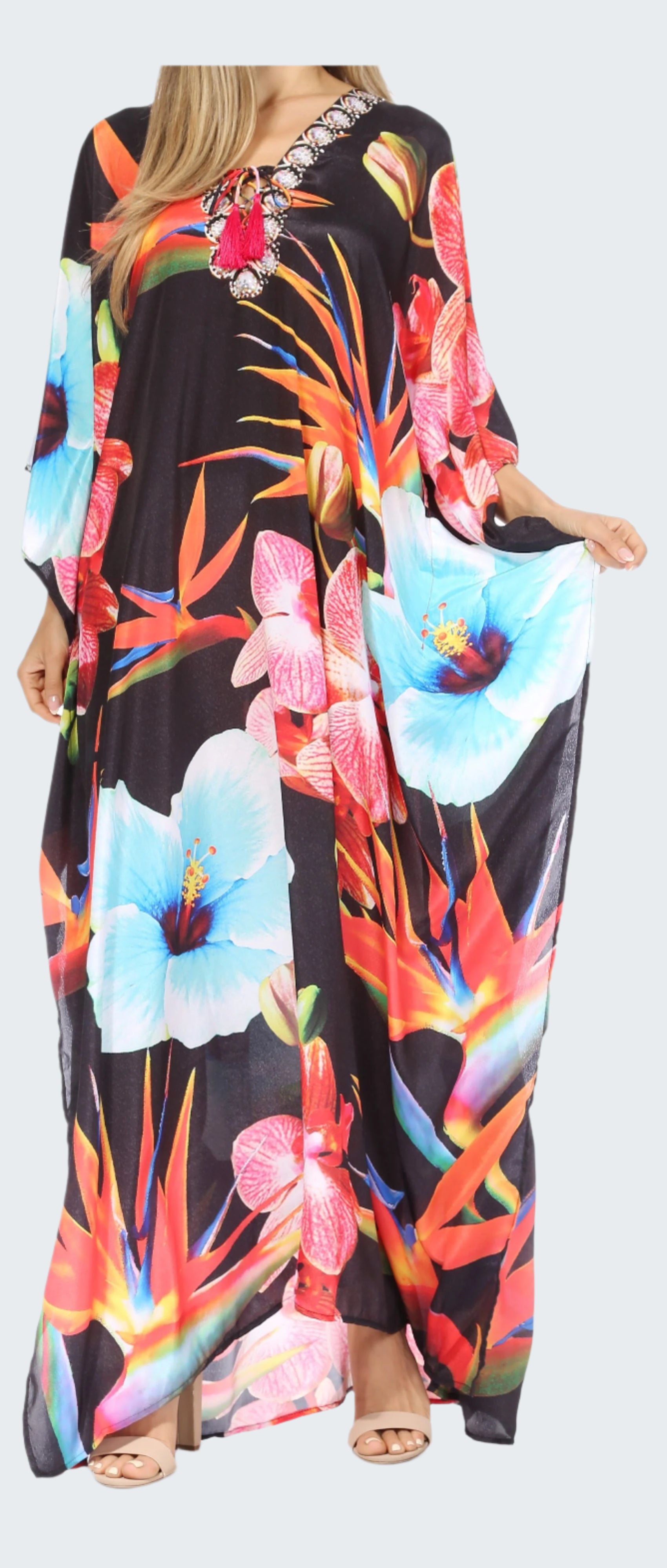 Woman wearing a long, colorful floral dress with a black background