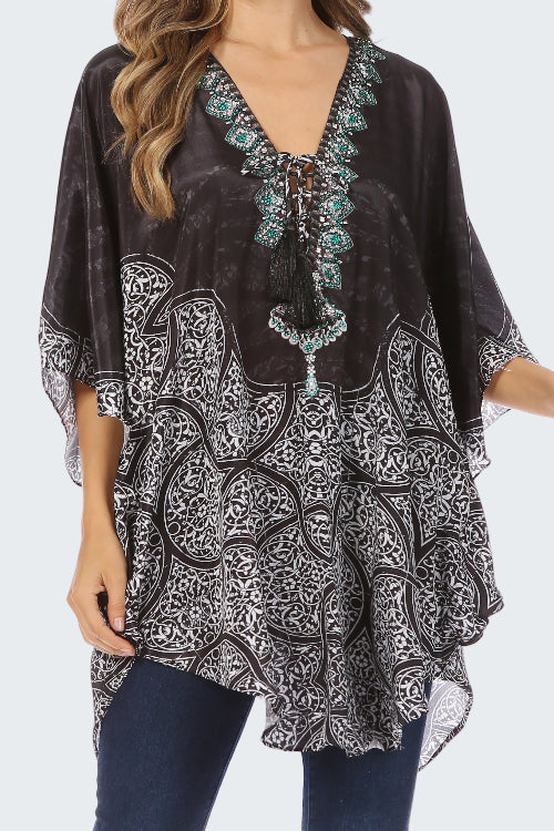 Black patterned top with turquoise embellishments worn by a model on a white background