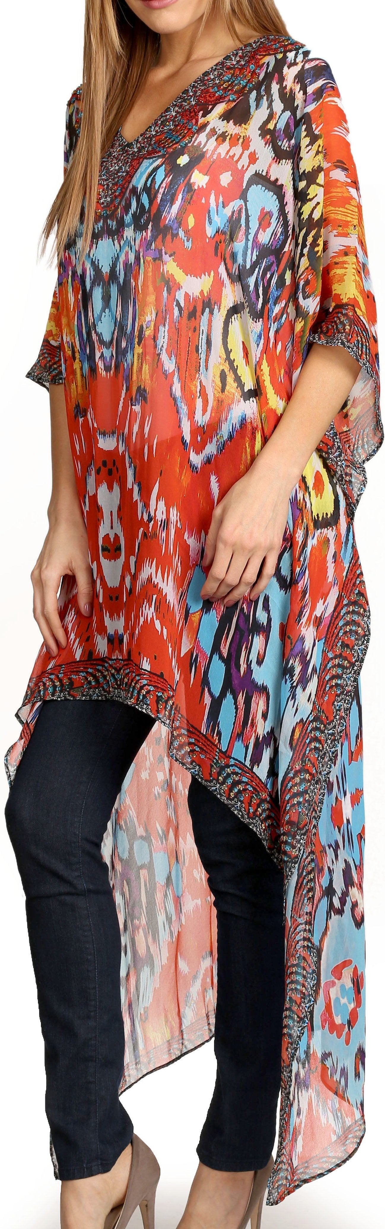 Woman wearing a colorful patterned dress over black pants on a white background