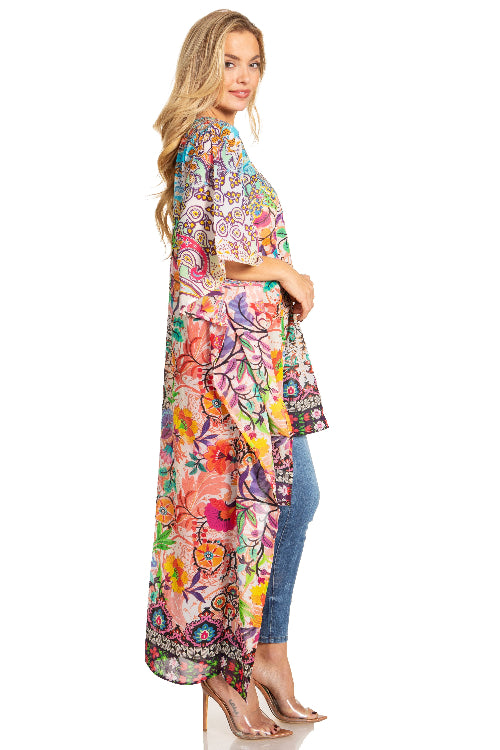 Woman wearing a colorful floral kimono with blue jeans on a white background