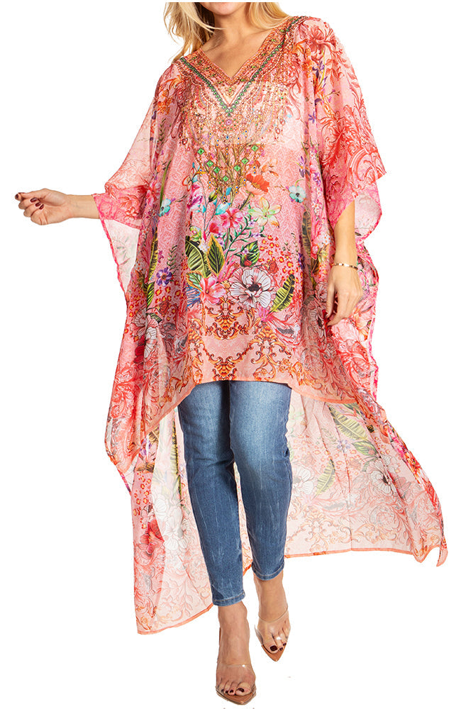 Woman wearing a floral embroidered kaftan over jeans on a white background