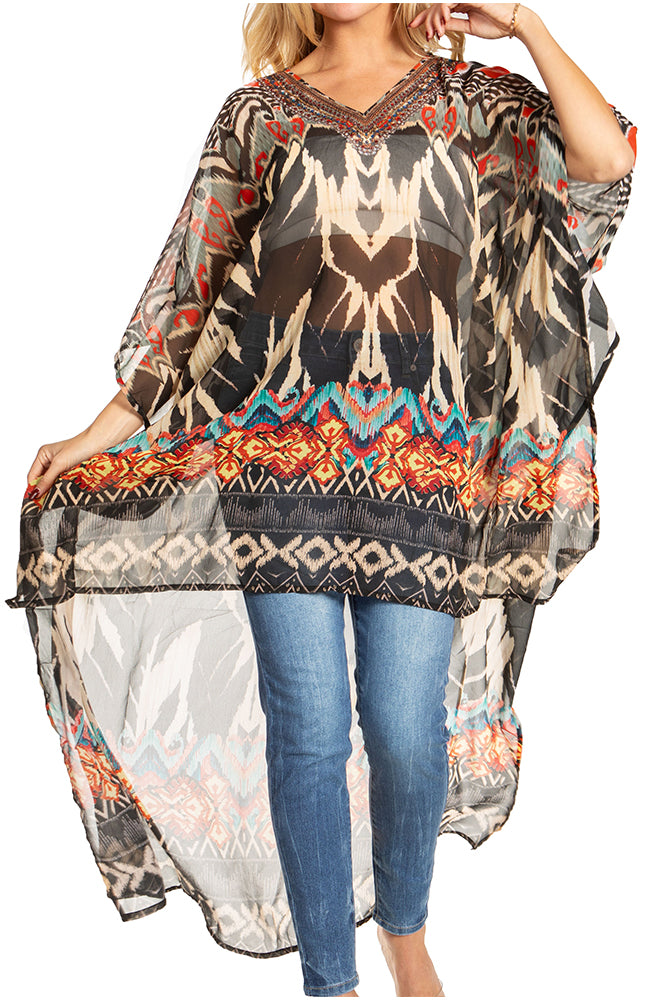 Person wearing a patterned poncho over a plain top and jeans on a white background